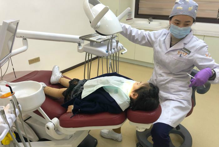 温州鹿城爱牙故事口腔医生正在为患者治疗